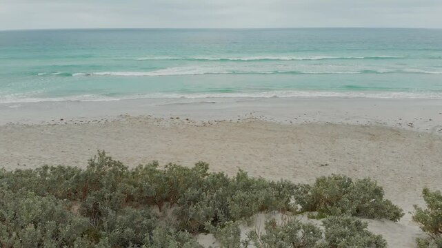 Aerial view of beautiful beach and tranquil sea with dunes and village, Geraldton, Australia.