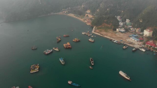 Aerial view of serene Halong Bay with rocks, boats, and tranquil sea at sunrise, Halong Bay, Vietnam.