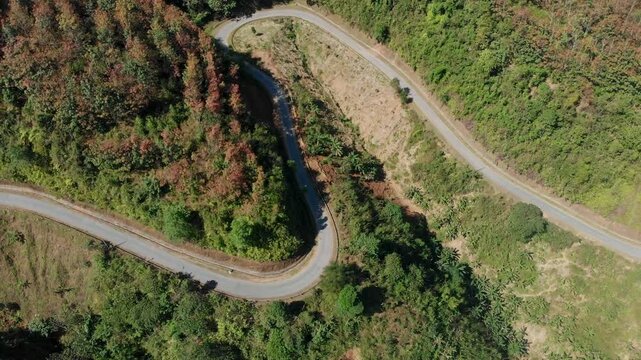 Aerial view of winding road through serene mountains and lush forests, Sin Ho, Vietnam.
