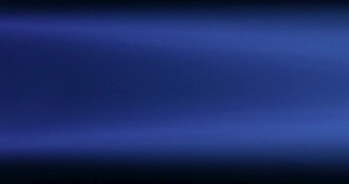 A close-up of a gas burner wick burning with a blue flame on a black background in a horizontal position.