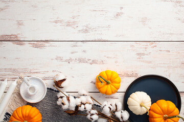 Autumn flat lay composition with pumpkins, checkered plaid, cotton and candles on rustic wooden table. Flat lay, top view.