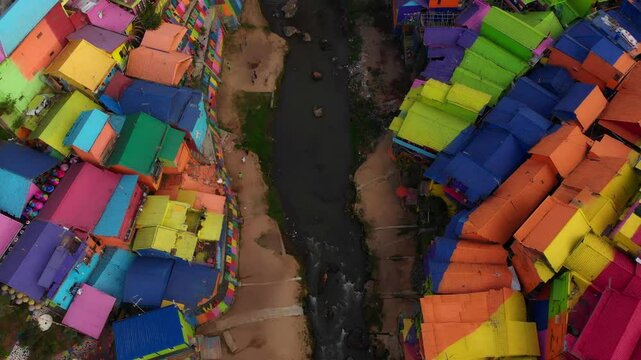 Aerial view of jodipan rainbow village with colorful houses and a river, malang city, east java, indonesia.