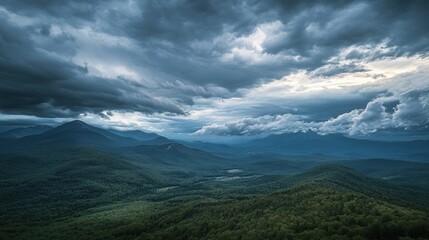 Fototapeta premium A dramatic landscape featuring mountains under a cloudy sky, evoking a sense of tranquility.