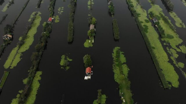 Aerial view of serene island with picturesque houses surrounded by tranquil water and lush vegetation, Breukelen, Netherlands.