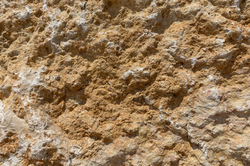 The rough texture of Jerusalem stone with an orange hue.