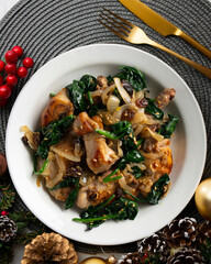 Delicious Rabbit stewed with spinach and raisins. Top view table with Christmas decorations.