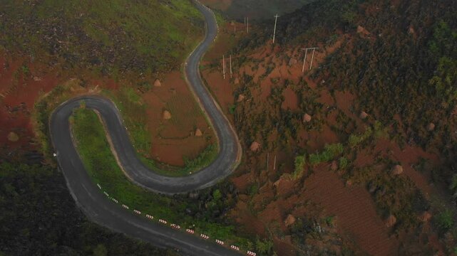 Aerial view of winding road through majestic mountains and serene valley at Ma Pi Leng Pass, Meo Vac, Ha Giang, Vietnam.