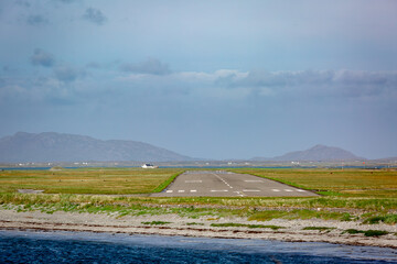 Fototapeta premium View of Benbecula airport runway formally known as RAF Benbecula on a summers day from across the bay