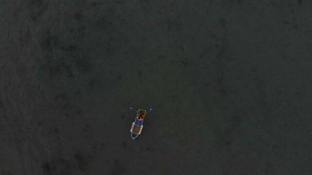 Aerial view of a beautiful sunset over the calm sea with a boat, Tanjung Binga, Indonesia.