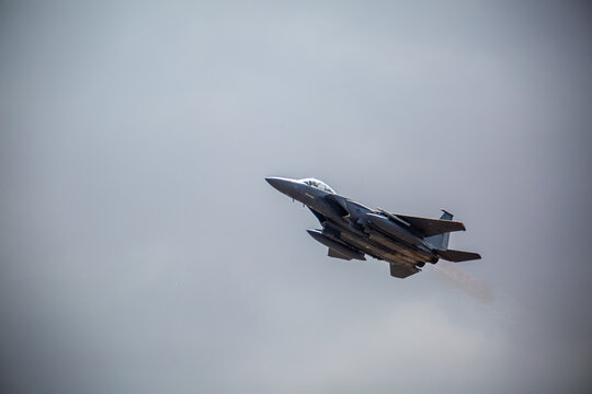 F15 fighter jet taking off with landing gear up, from a public road