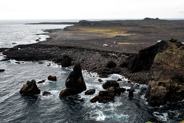 Rocky cliffs and stormy sea under a cloudy sky.