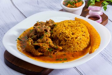 A mouthwatering dish of Seco de chivo chancho featuring a rich and savory sauce, served with tender chunks of goat, pork, and beef. Accompanied by a generous portion of moros de lenteja (lentil rice)