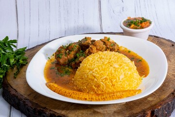 A mouthwatering dish of Seco de chivo chancho featuring a rich and savory sauce, served with tender chunks of goat, pork, and beef. Accompanied by a generous portion of moros de lenteja (lentil rice)