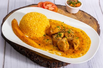 A mouthwatering dish of Seco de chivo chancho featuring a rich and savory sauce, served with tender chunks of goat, pork, and beef. Accompanied by a generous portion of moros de lenteja (lentil rice)
