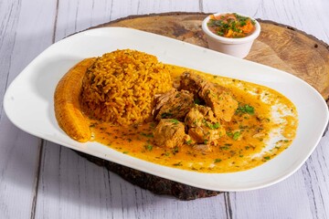 A mouthwatering dish of Seco de chivo chancho featuring a rich and savory sauce, served with tender chunks of goat, pork, and beef. Accompanied by a generous portion of moros de lenteja (lentil rice)