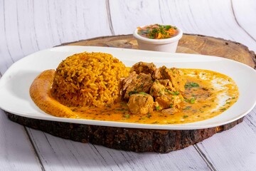A mouthwatering dish of Seco de chivo chancho featuring a rich and savory sauce, served with tender chunks of goat, pork, and beef. Accompanied by a generous portion of moros de lenteja (lentil rice)