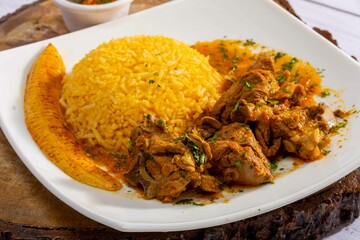 A mouthwatering dish of Seco de chivo chancho featuring a rich and savory sauce, served with tender chunks of goat, pork, and beef. Accompanied by a generous portion of moros de lenteja (lentil rice)