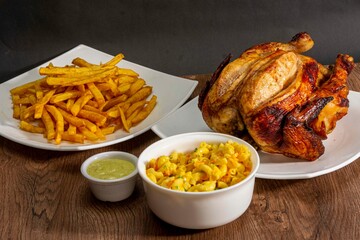 Deliciously charred and smoky Pollo a la Brasa (grilled chicken) served whole and in pieces, accompanied by crispy fries, fresh salad, and a flavorful dipping sauce. A classic Latin American dish, coo