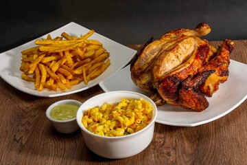 Deliciously charred and smoky Pollo a la Brasa (grilled chicken) served whole and in pieces, accompanied by crispy fries, fresh salad, and a flavorful dipping sauce. A classic Latin American dish, coo