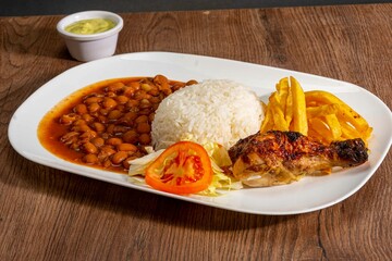 Deliciously charred and smoky Pollo a la Brasa (grilled chicken) served whole and in pieces, accompanied by crispy fries, fresh salad, and a flavorful dipping sauce. A classic Latin American dish, coo