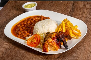 Deliciously charred and smoky Pollo a la Brasa (grilled chicken) served whole and in pieces, accompanied by crispy fries, fresh salad, and a flavorful dipping sauce. A classic Latin American dish, coo