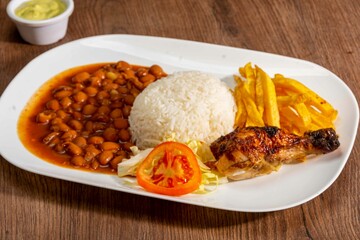 Deliciously charred and smoky Pollo a la Brasa (grilled chicken) served whole and in pieces, accompanied by crispy fries, fresh salad, and a flavorful dipping sauce. A classic Latin American dish, coo