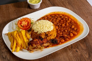 Deliciously charred and smoky Pollo a la Brasa (grilled chicken) served whole and in pieces, accompanied by crispy fries, fresh salad, and a flavorful dipping sauce. A classic Latin American dish, coo