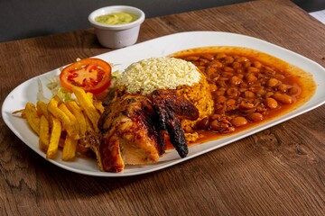 Deliciously charred and smoky Pollo a la Brasa (grilled chicken) served whole and in pieces, accompanied by crispy fries, fresh salad, and a flavorful dipping sauce. A classic Latin American dish, coo