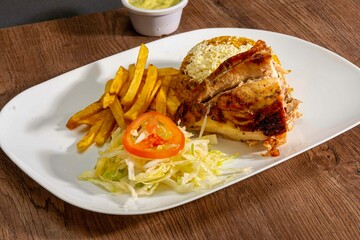 Deliciously charred and smoky Pollo a la Brasa (grilled chicken) served whole and in pieces, accompanied by crispy fries, fresh salad, and a flavorful dipping sauce. A classic Latin American dish, coo