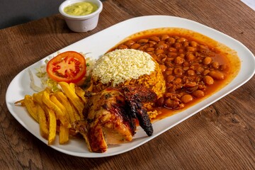 Deliciously charred and smoky Pollo a la Brasa (grilled chicken) served whole and in pieces, accompanied by crispy fries, fresh salad, and a flavorful dipping sauce. A classic Latin American dish, coo