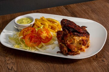 Deliciously charred and smoky Pollo a la Brasa (grilled chicken) served whole and in pieces, accompanied by crispy fries, fresh salad, and a flavorful dipping sauce. A classic Latin American dish, coo