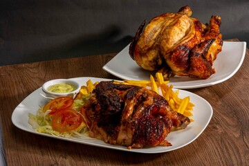 Deliciously charred and smoky Pollo a la Brasa (grilled chicken) served whole and in pieces, accompanied by crispy fries, fresh salad, and a flavorful dipping sauce. A classic Latin American dish, coo