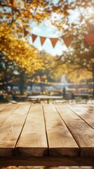 Obraz premium Wooden table with a blurred background of autumn trees and festive bunting, perfect for outdoor event imagery.