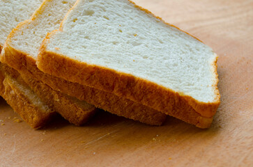 Fresh slices of bread displayed on wooden table. Healthy food concept