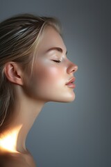 Naklejka premium Portrait of a serene woman with closed eyes, highlighting smooth skin and soft lighting, evoking peace and beauty.