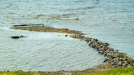 Rocky bank of a large river on a sunny day