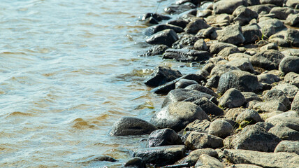 Rocky bank of a large river on a sunny day