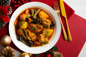 Delicious Rabbit stewed with vegetables and potatoes. Top view table with christmas decoration.