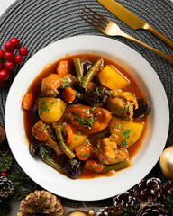 Delicious Rabbit stewed with vegetables and potatoes. Top view table with christmas decoration.