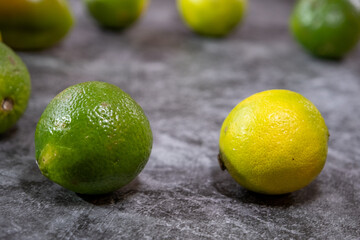 Limetten in grün und gelb auf grauen Hintergrund