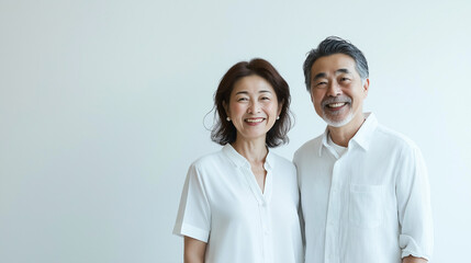ミドル・シニア夫婦の写真：白背景で撮影された中年・高齢者の笑顔のポートレート