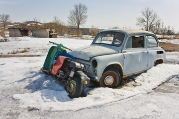 Old car in winter under the snow
