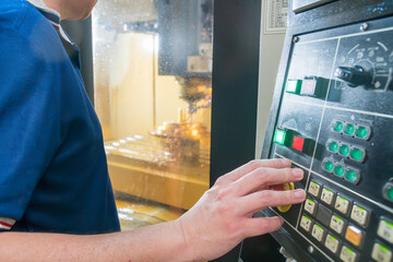 Close up scene the CNC machine operator working with CNC milling machine.