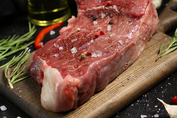 Raw meat on a cutting board with spices. Steak. Cooking.