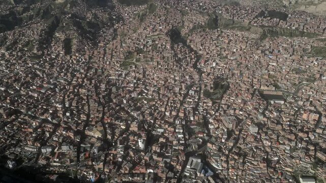 Aerial view of Hernando Siles Stadium surrounded by dense urban sprawl and mountains, La Paz, Bolivia.