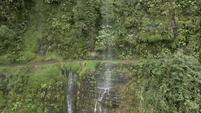 Aerial view of lush green forest and breathtaking waterfalls along the dangerous Death Road, Los Yungas, Bolivia.