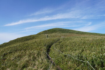 雲がかかった青空へと延びる登山道