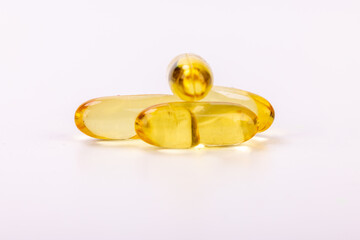 High-resolution photo of yellow medicine capsules on a white background