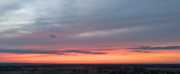 Panoramic view of an orange sky at sunset, with vibrant hues and a dramatic evening sky.