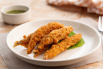 Deep fried Capelin Fish (Shishamo),Thai fried battered egg fish in white plate.snack food served with seafood sauce.
